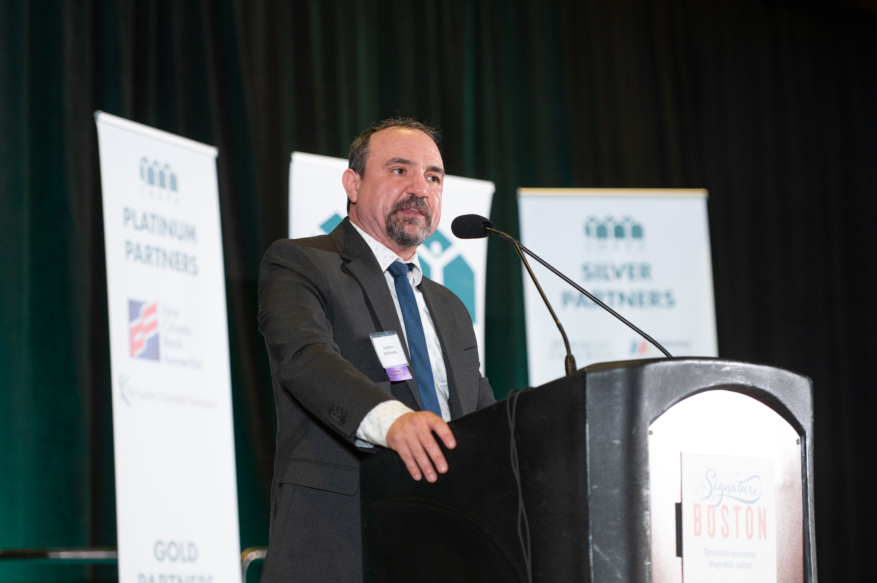 Andrew DeFranza speaking at a podium at the CHAPA Dinner